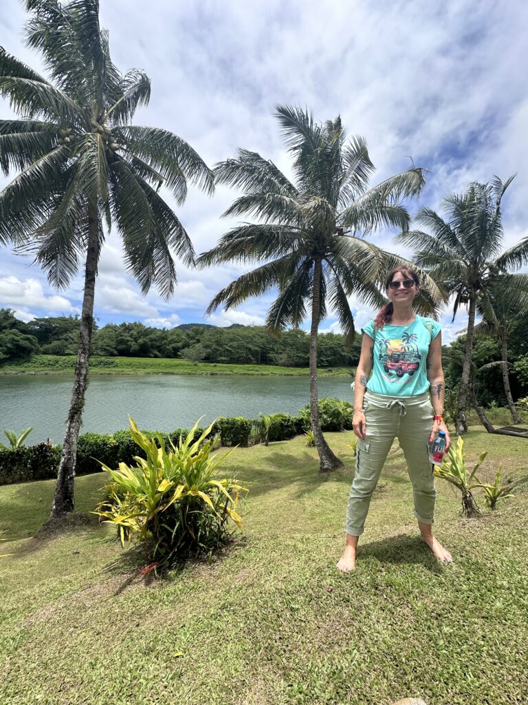 Me at Raiwaqa village with palm trees and the river in the background